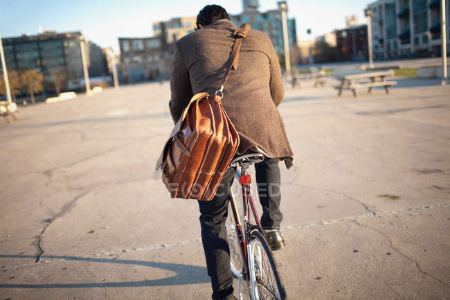 Visão traseira do homem andar de bicicleta na rua da cidade — Fotografia de Stock