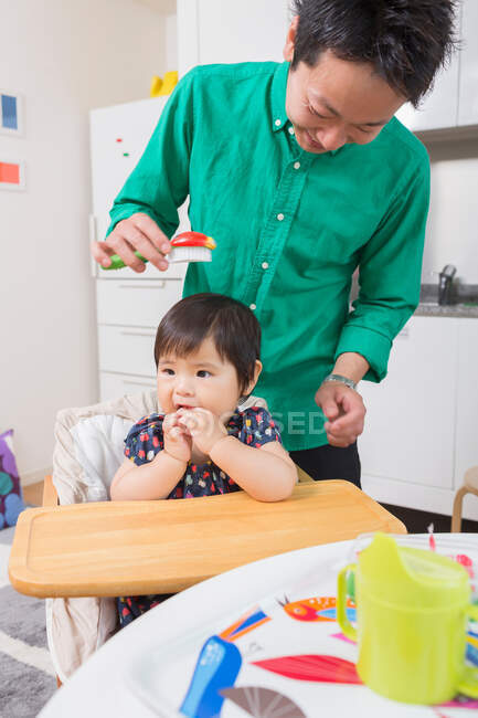 Father combing baby's hair — Stock Photo
