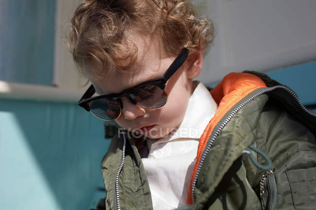 Petit garçon portant des lunettes de soleil de style mod et parka — Photo de stock