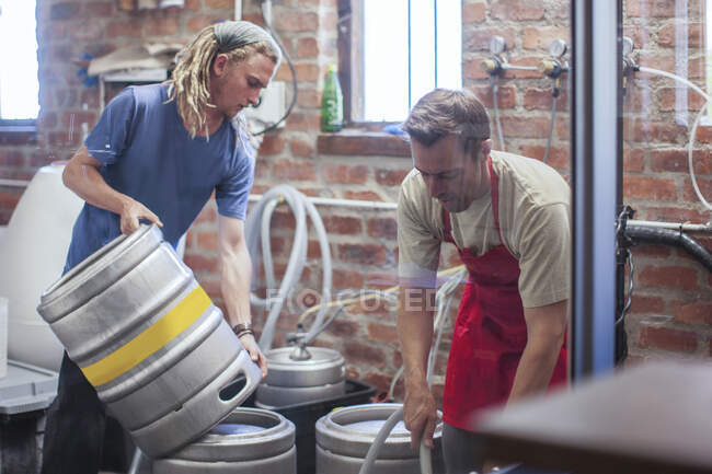 Cape Town, South Africa, two young males pouring out beer in brewery containers — Stock Photo