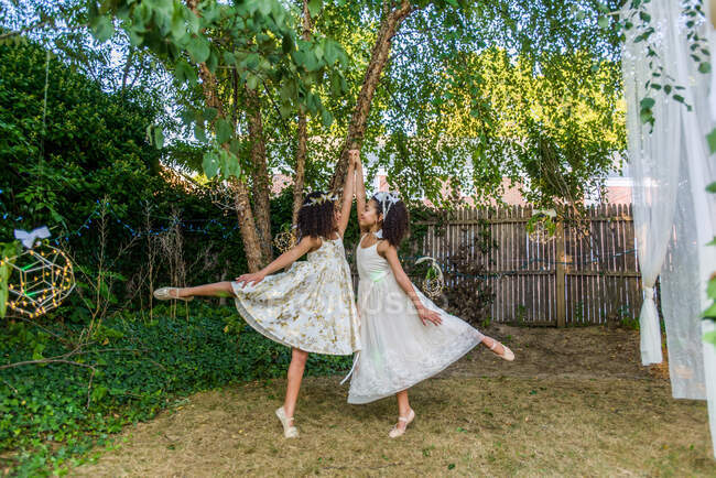 Two young girls, dressed as fairies, dancing outdoors — Stock Photo