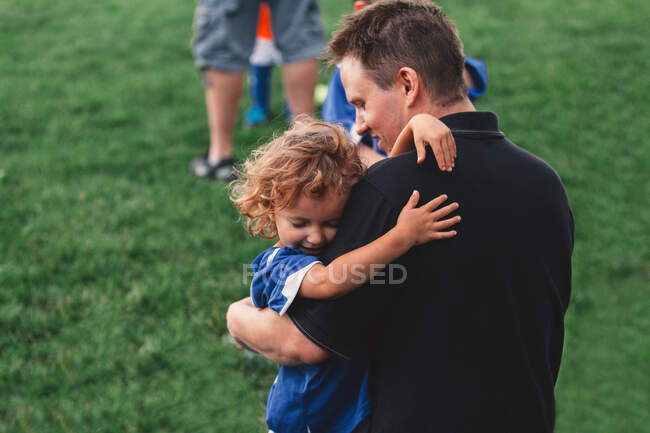 Chica abrazando a su padre en el campo - foto de stock