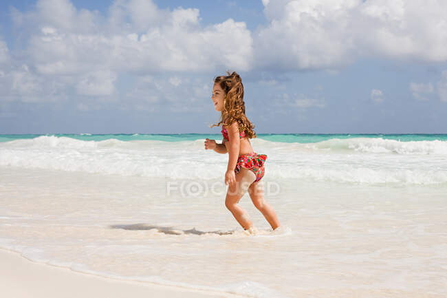 Девушка, бегущая в море — стоковое фото