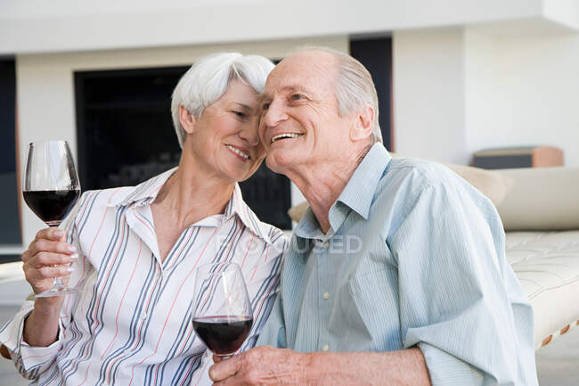 Una pareja de ancianos tomando una copa de vino tinto - foto de stock