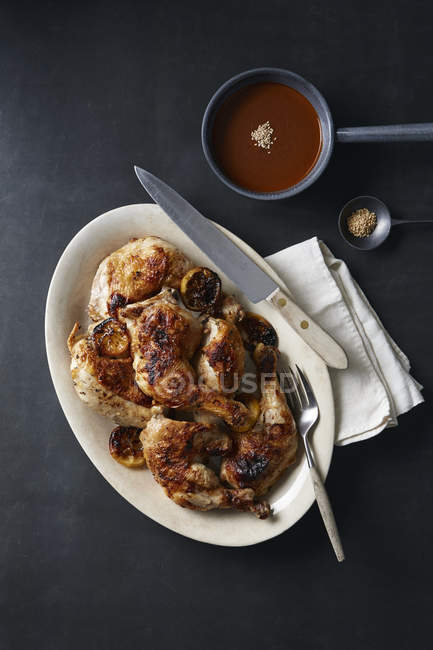 Roasted chicken in dish and mole poblano sauce — Stock Photo