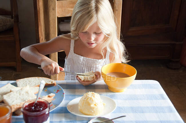Les filles étalent du beurre sur le pain — Photo de stock