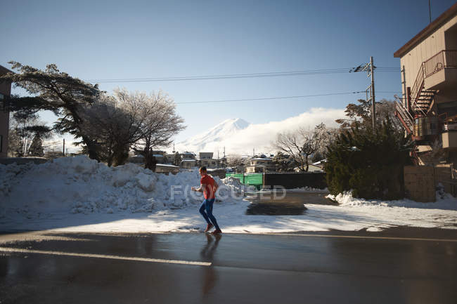 Зрелый мужчина бежит по дороге зимой, озеро Кавагутико, гора Фудзи, Япония — стоковое фото