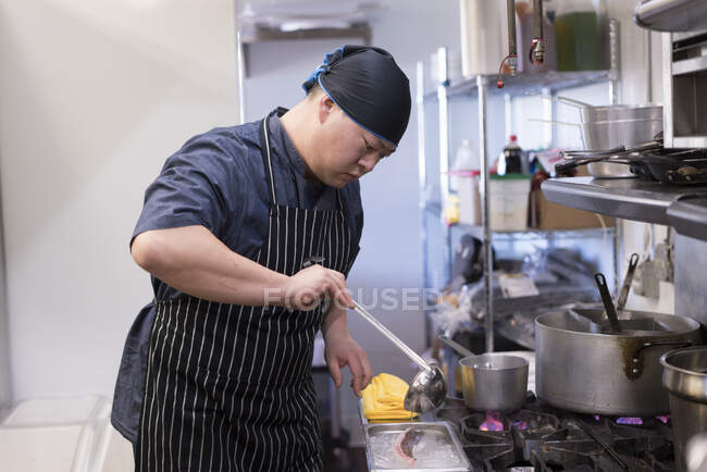 Chef in kitchen preparing food — Stock Photo
