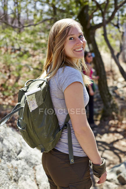 Porträt einer Wanderin, die in Wald, Harriman State Park, New York State, USA zurückblickt — Stockfoto