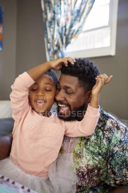Menina e pai cantando juntos na sala de estar — Fotografia de Stock
