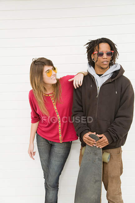Young couple by wall — Stock Photo