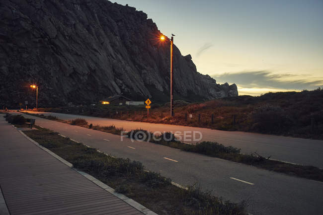 Morro Bay Rock y carretera de la costa al atardecer - foto de stock