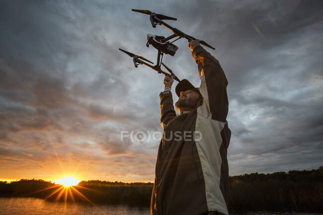 Человек запускает дрон на восходе солнца, Хомосасса, Флорида, США — стоковое фото