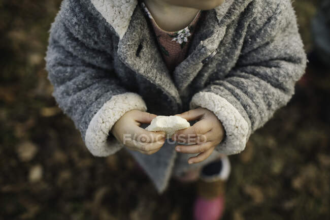 Baby girl holding piece of bread — Stock Photo
