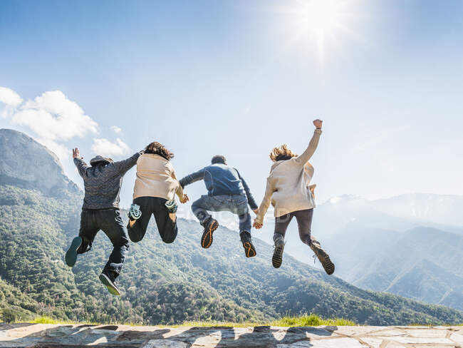 Group of people jumping in air, rear view, Sequoia National Park, California, USA — Stock Photo