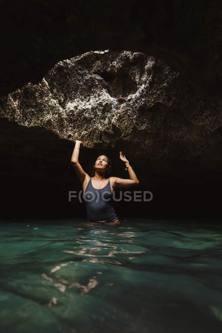 Femme dans la grotte remplie d'eau et regardant vers le haut, Oahu, Hawaii, USA — Photo de stock