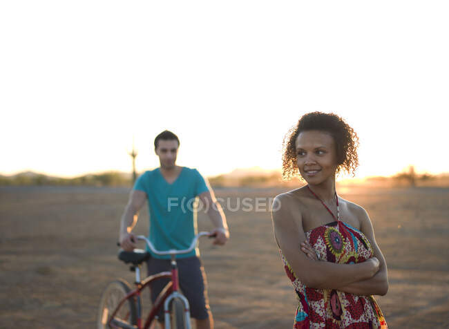 Young couple standing in desert at sunset — Stock Photo