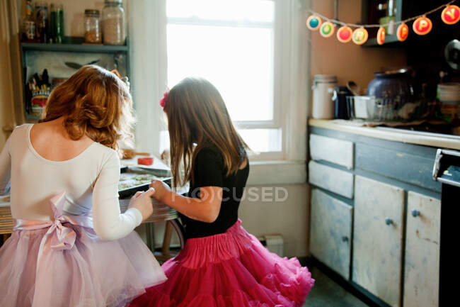 Meninas na cozinha assar biscoitos — Fotografia de Stock