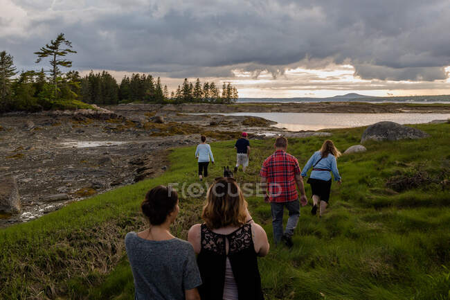 Rückansicht einer erwachsenen Familie zu Fuß zur Küste in Maine, USA — Stockfoto