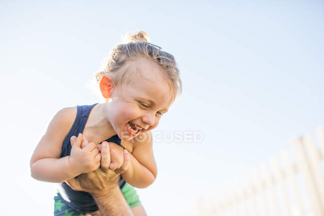 Young boy being lifted in air by father — Stock Photo