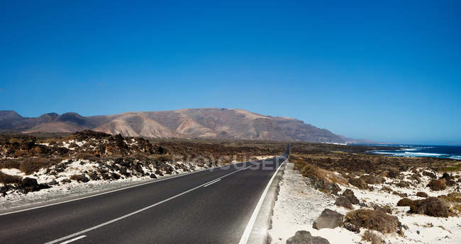 Strada vuota attraverso Lanzarote, Isole Canarie, Spagna — Foto stock