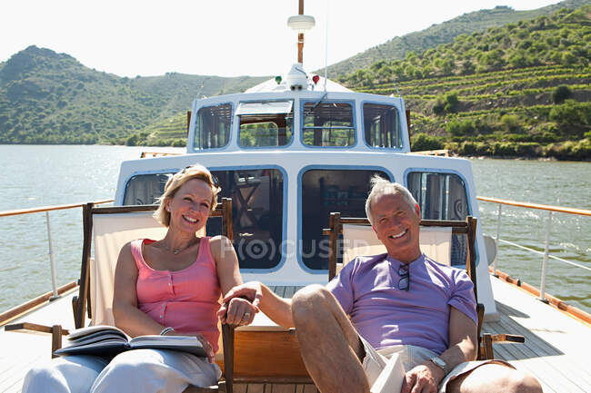 Старша пара сидить на кріслах на човні — стокове фото