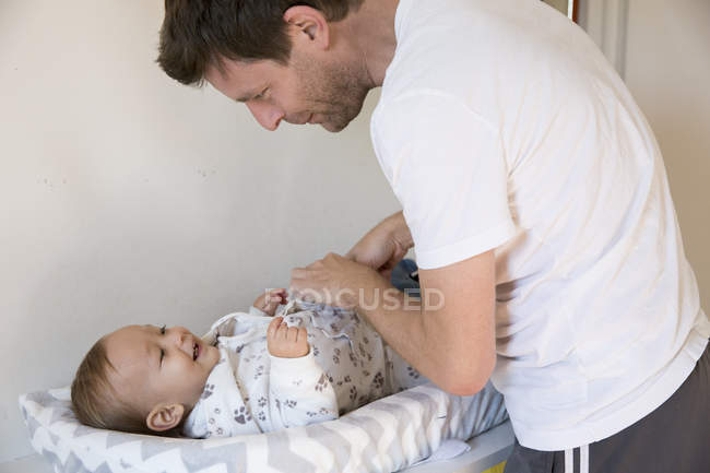 Father dressing young son — Stock Photo