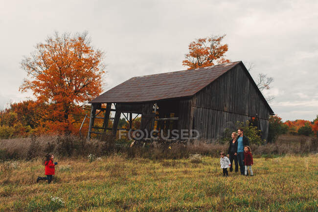 Средняя взрослая семья с тремя дочерьми, прогуливающимися в сельской местности — стоковое фото