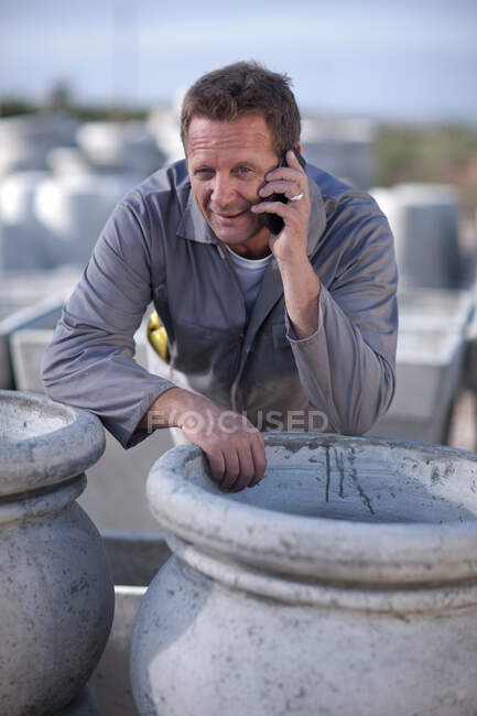 Работник завода разговаривает по сотовому телефону — стоковое фото
