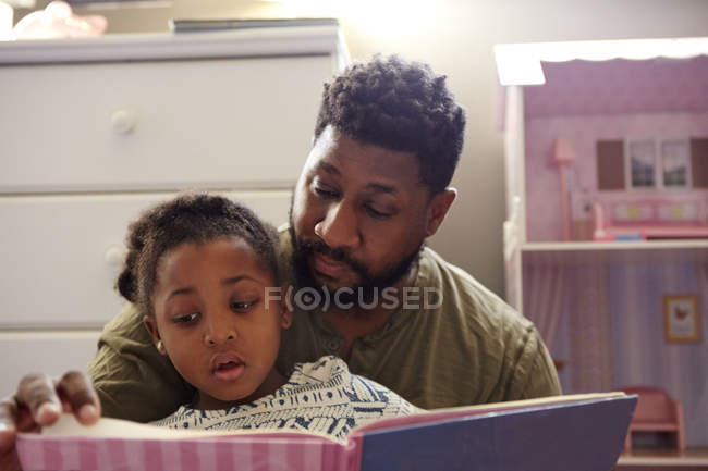 Padre leyendo a hija - foto de stock