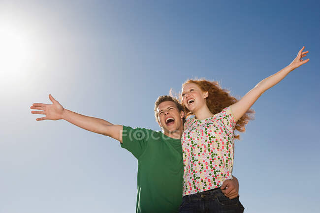 Um casal com os braços levantados — Fotografia de Stock