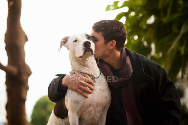 Man kissing dog outdoors — Stock Photo