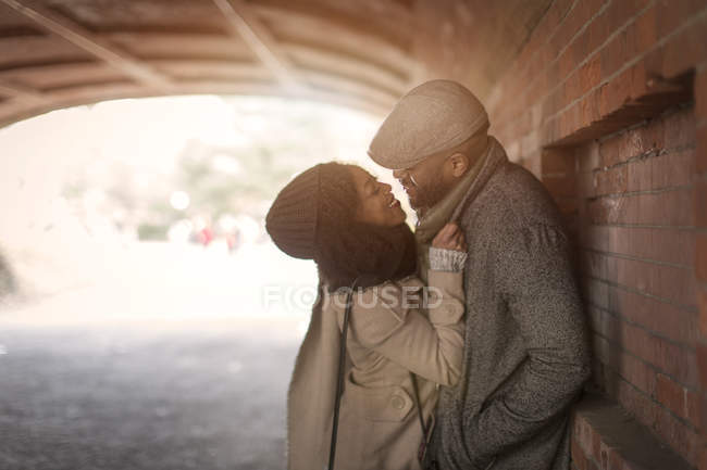 Romántica pareja feliz disfrutando de la ciudad durante las vacaciones de invierno en el túnel del parque - foto de stock