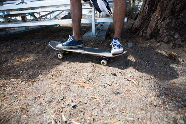 Beine und Füße eines männlichen Skateboarders am Stadionsitz — Stockfoto