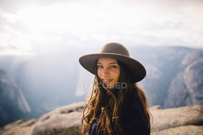 Retrato de uma jovem mulher no topo da montanha, com vista para o Parque Nacional de Yosemite, Califórnia, EUA — Fotografia de Stock