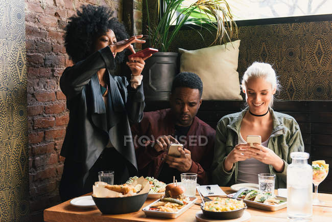Друзі фотографують приготовану їжу в кафе — стокове фото
