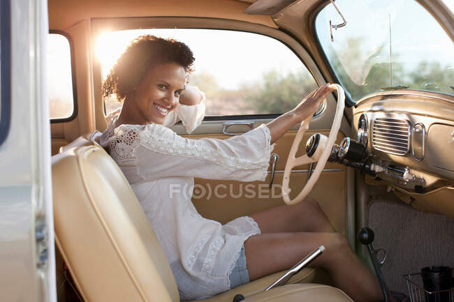 Young woman sitting in car on road trip, portrait — Stock Photo