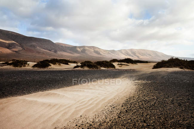 Sable et paysage de Famara plage — Photo de stock