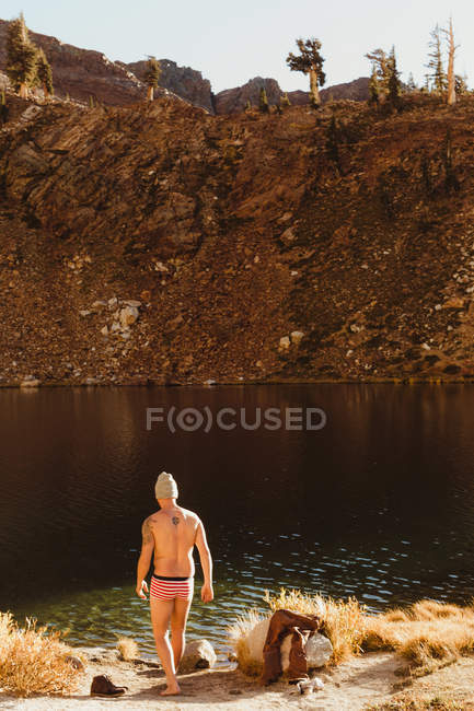 Male hiker in swimming trunks by lake, Mineral King, Sequoia National Park, California, USA — Stock Photo