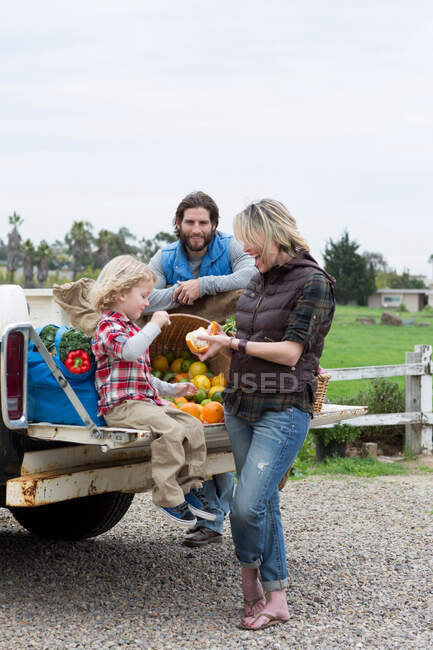 Family with produce in truck bed — Stock Photo