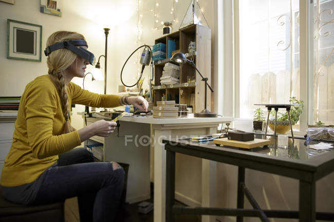 Fabricante de joyas femenino preparando metal en estudio de diseño - foto de stock