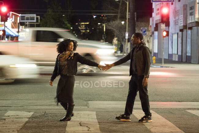 Casal segurando as mãos na travessia de pedestres, Los Angeles, Califórnia, EUA — Fotografia de Stock