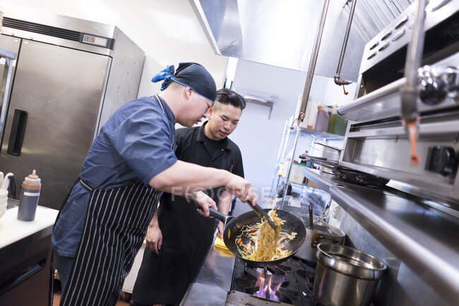 Chefs in kitchen preparing food — Stock Photo