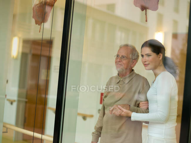 Жінка допомагає старшому чоловікові — стокове фото