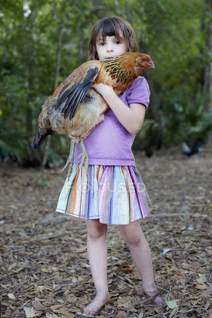 Girl holding hen outdoors — Stock Photo