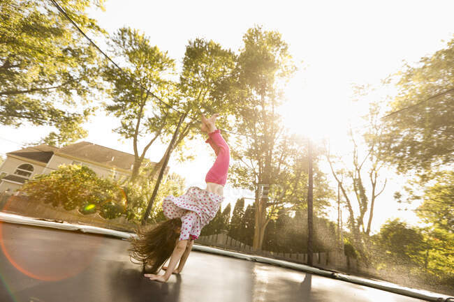 Junges Mädchen macht Handstand auf großem Trampolin, niedriger Winkel — Stockfoto