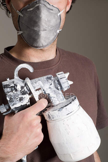 Decorator holding paint supplies and wearing face mask — Stock Photo
