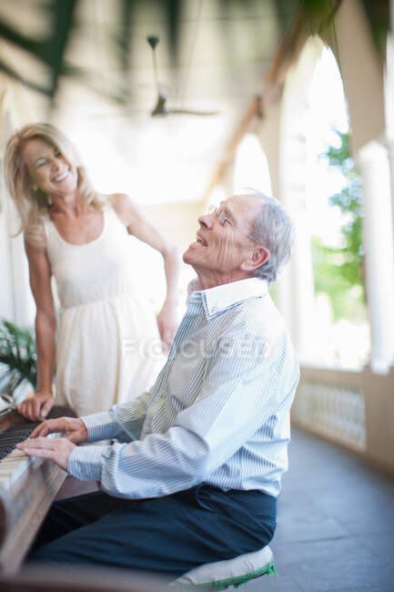 Homme plus âgé chantant au piano — Photo de stock