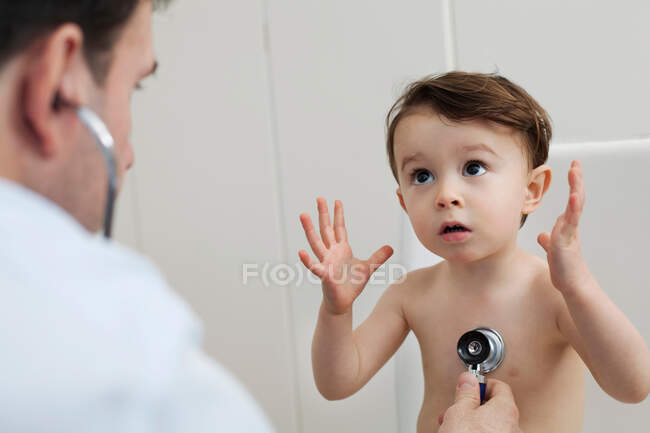 Доктор використовує стетоскоп для перевірки маленького хлопчика — стокове фото