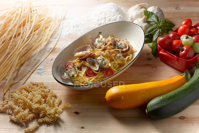 Pasta with vegetables and herbs on a wooden background — Stock Photo